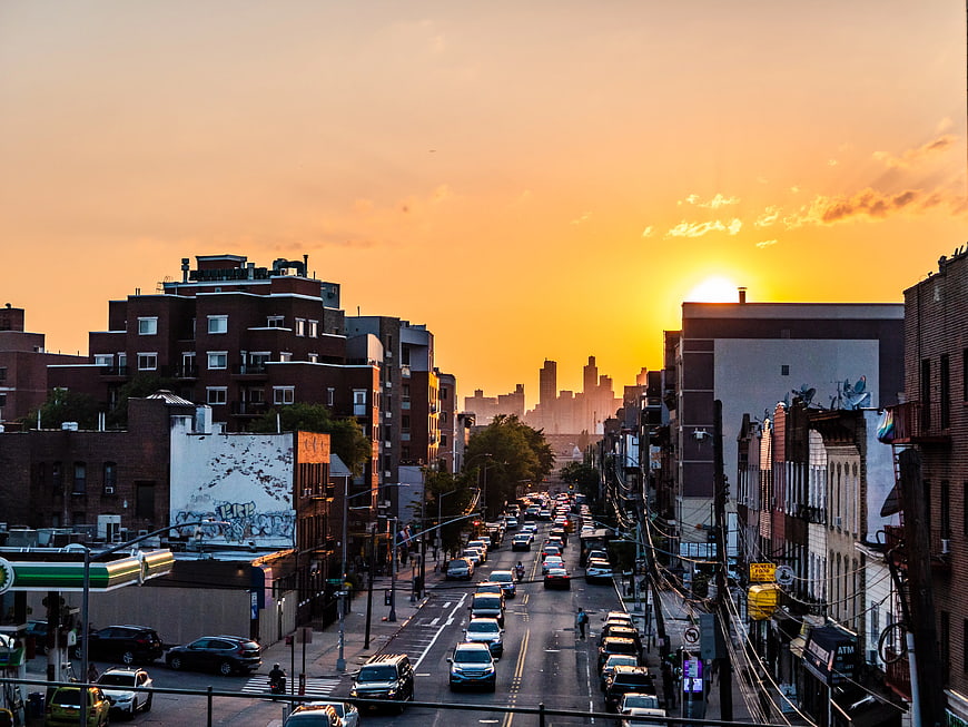 Golden Sunset Over Urban Street with Traffic and City Skyline