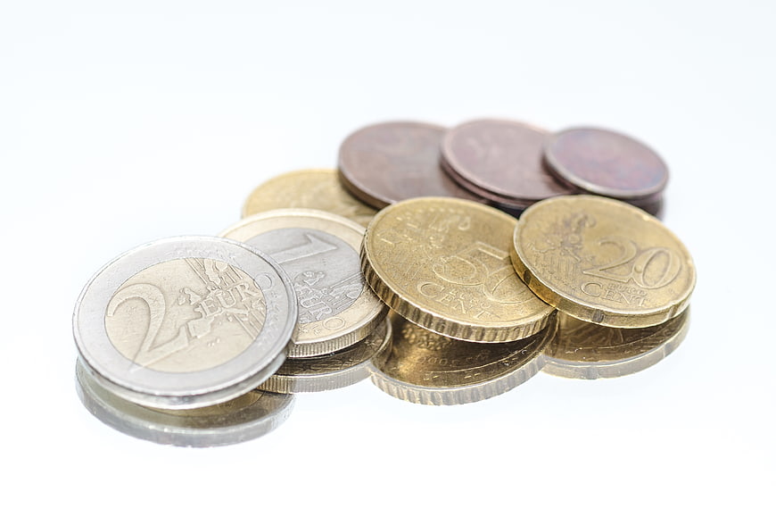 Euro coins on a reflective white surface