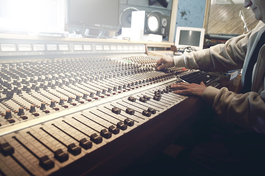 Sound Engineer Mixing Audio on Large Analog Console