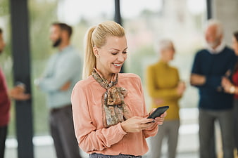 Smiling Businesswoman Using Smartphone in Office