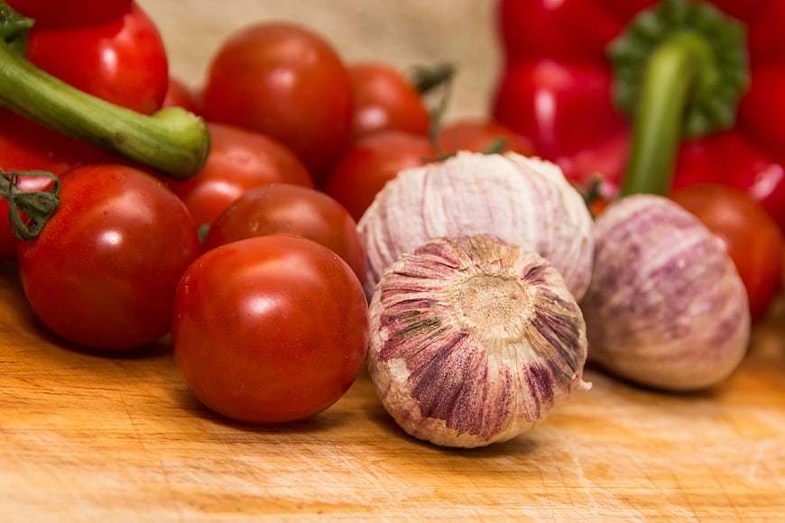 Fresh Garlic and Tomatoes on Wooden Cutting Board
