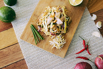 Top View of Pad Thai with Fresh Ingredients on Wooden Board