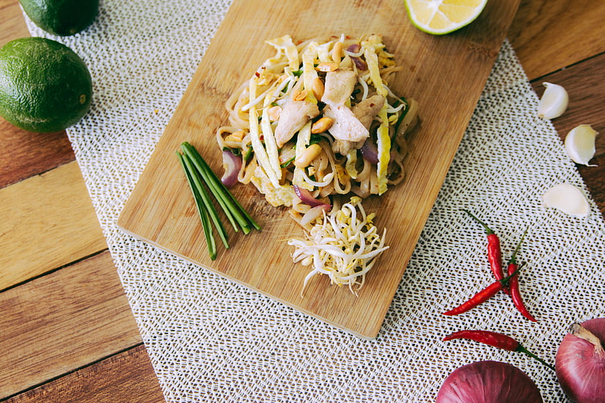 Top View of Pad Thai with Fresh Ingredients on Wooden Board