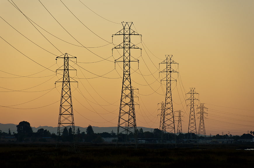 Silhouetted Power Lines Against Golden Sunset Sky