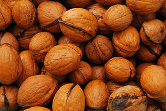 Close-up of whole walnuts in shells forming a textured natural background