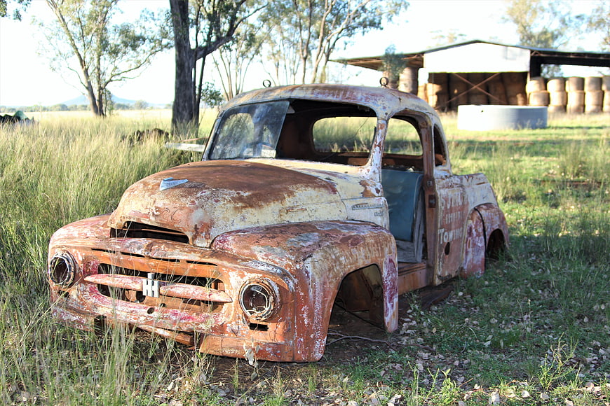 Rusty vintage pickup truck abandoned in rural field