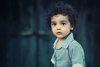 Portrait of a cute toddler boy with curly hair and big eyes