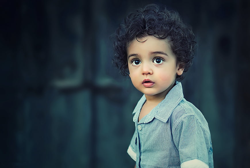 Portrait of a cute toddler boy with curly hair and big eyes