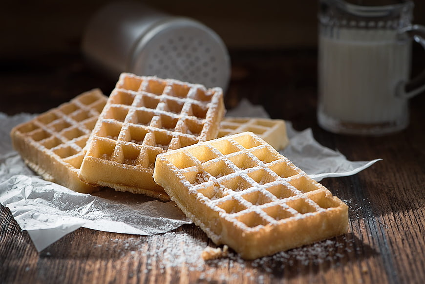 Freshly Baked Waffles With Powdered Sugar On Rustic Wooden Table