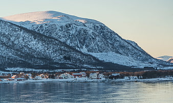 Snow-Covered Mountain Over Coastal Village at Sunset