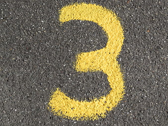 Yellow Number Three Painted on Asphalt Road Surface