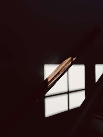 Dramatic shadow of wooden staircase railing on wall