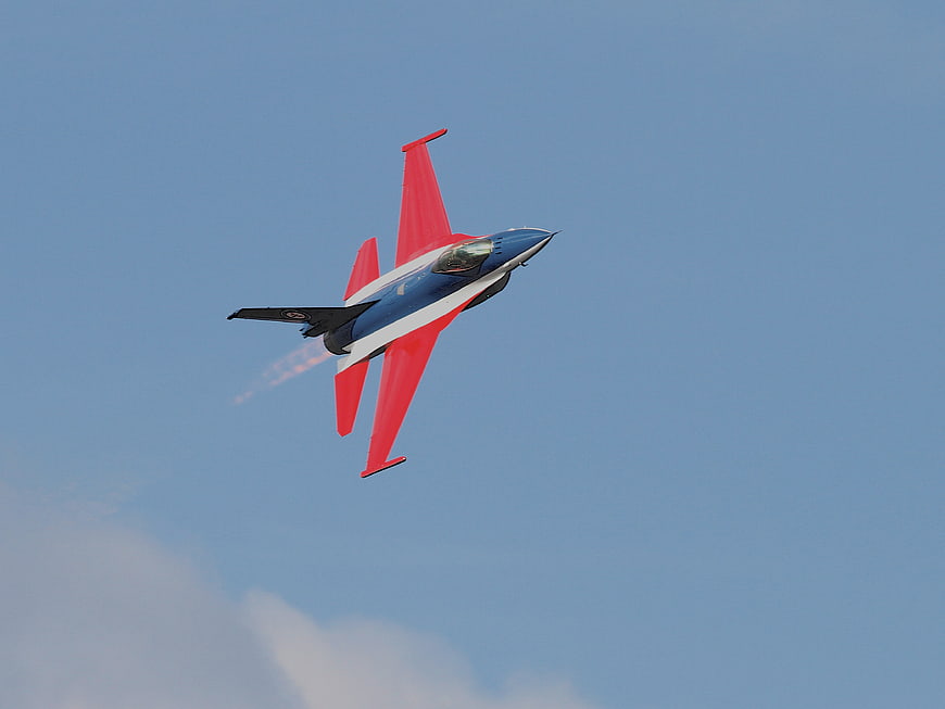Red and Blue Jet Plane Performing Aerial Maneuver in Sky