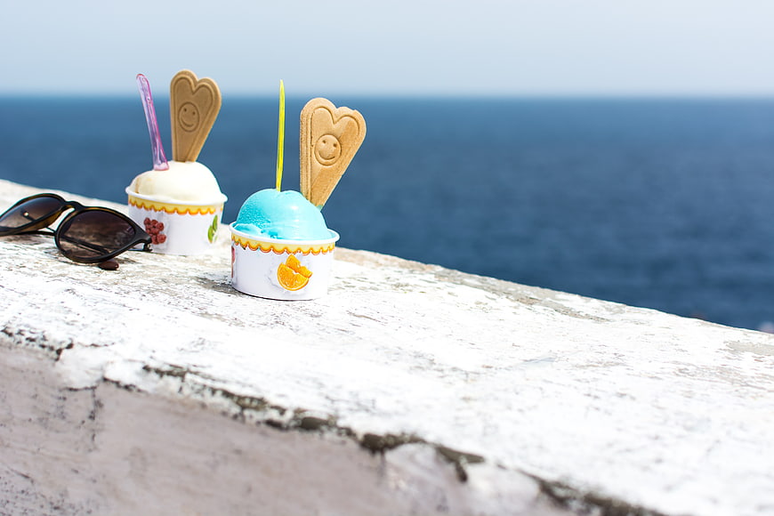 Blue and Vanilla Ice Cream Cups on White Wall by Sea