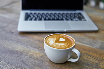 Latte Art Coffee Cup on Wooden Table with Laptop