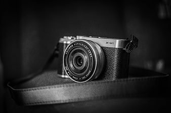 Black and white Fujifilm X-M1 camera on leather strap