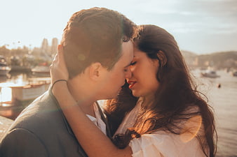 Romantic couple embracing by the waterfront at sunset
