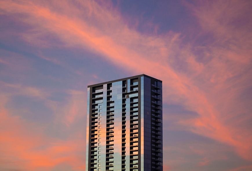 Modern Skyscraper Against Vibrant Pink and Purple Sunset Sky
