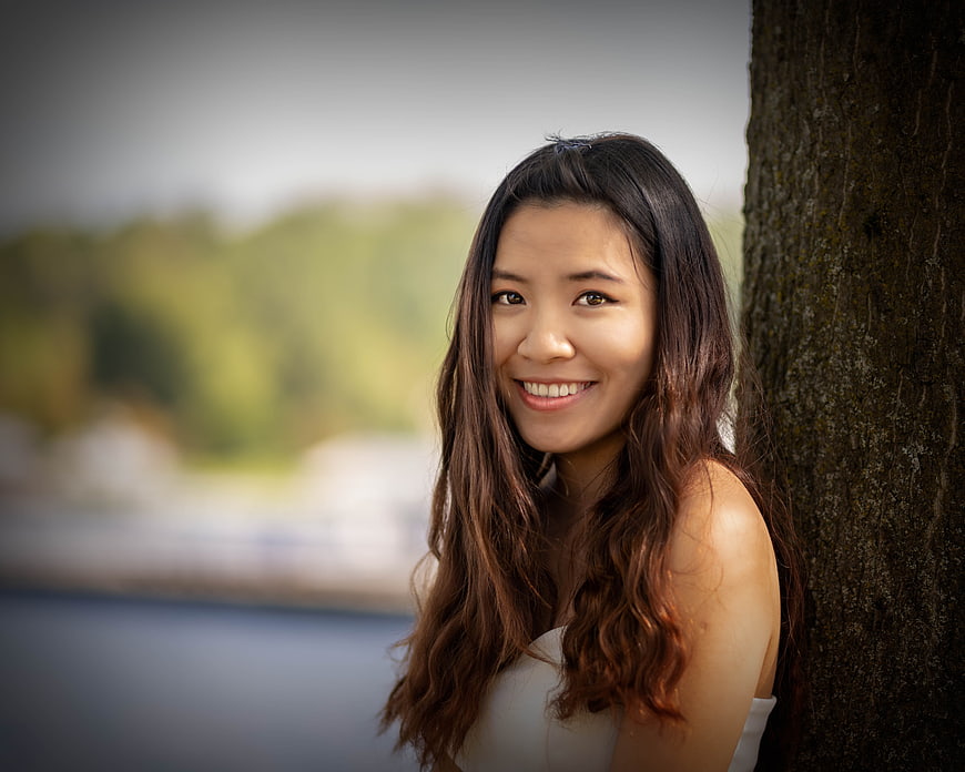 Smiling Asian Woman Portrait Leaning Against Tree Trunk