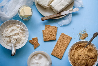 Flat lay of cheesecake ingredients on blue background