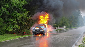 Car on Fire on Wet Road with Smoke