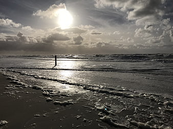 Dramatic Black and White Seascape with Sunlight on Wet Sand