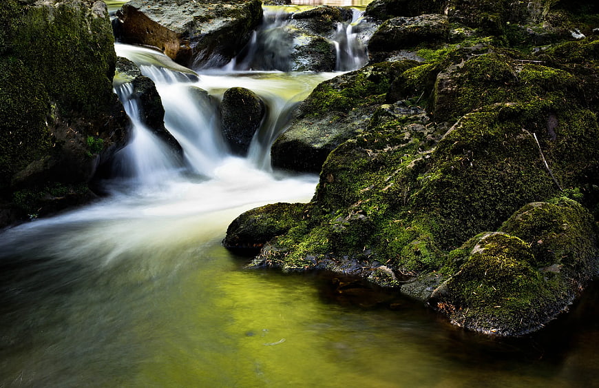 Mossy Rocks and Flowing Stream in Forest