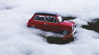 Red Mini Cooper Toy Car in Snowy Winter Landscape