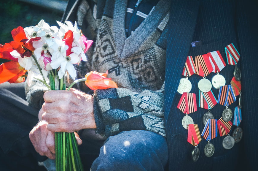 Senior Veteran Holding Flowers with Military Medals
