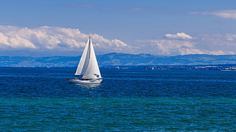 Sailboat Sailing On Lake Constance With Distant Mountains