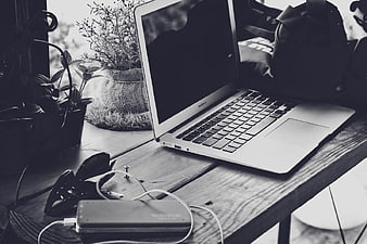 Black and white MacBook Pro on rustic wooden desk