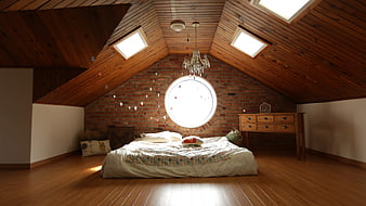 Cozy Attic Bedroom with Wooden Ceiling and Brick Wall