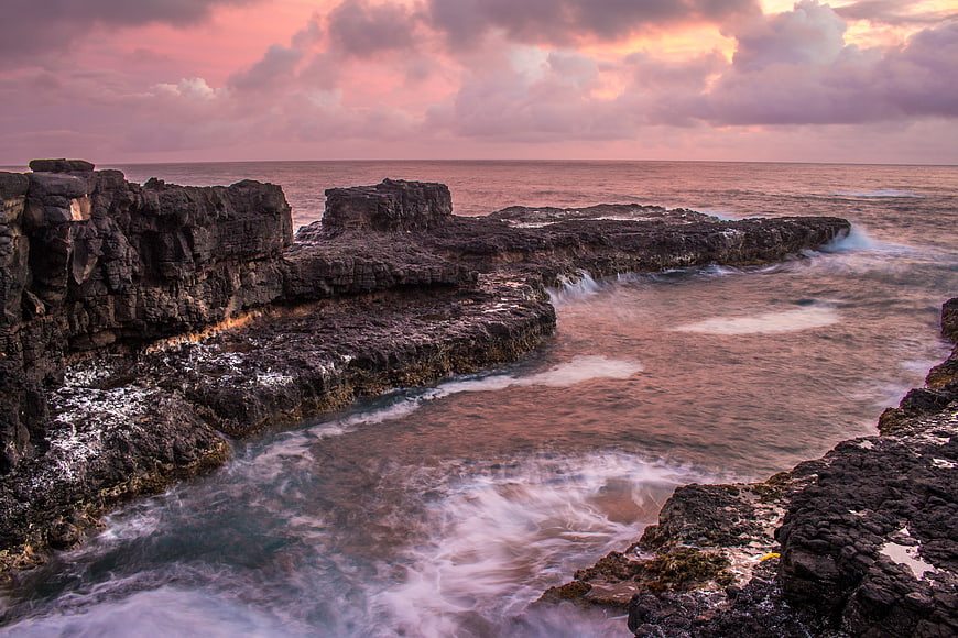 Dramatic Sunset Over Rocky Coastal Cliffs and Ocean Waves