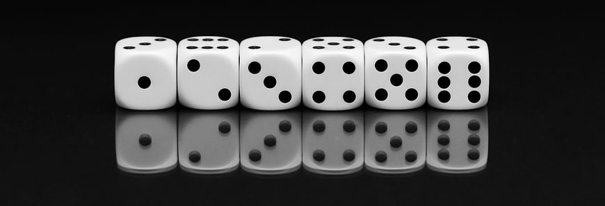 Row of white dice on black background with reflection