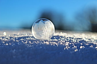 Frozen Soap Bubble with Ice Crystals on Snow