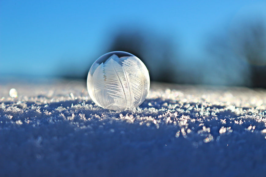 Frozen Soap Bubble with Ice Crystals on Snow