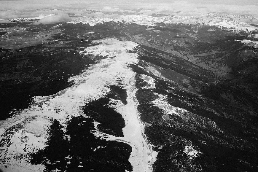 Aerial black and white view of snow-covered mountain range
