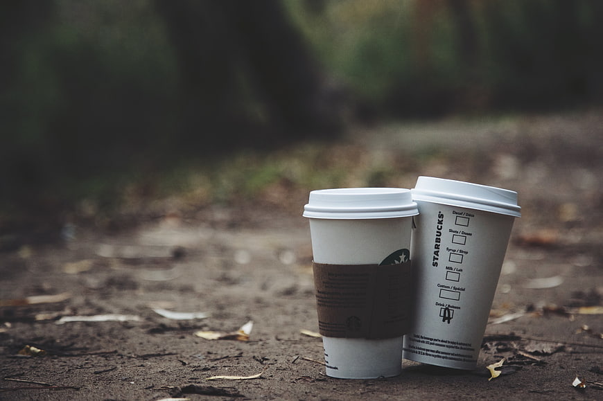 Two Starbucks Coffee Cups on Forest Path