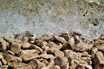 Clear Sea Waves Washing Over Smooth Beach Pebbles