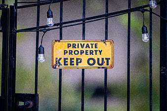 Weathered Private Property Keep Out Sign on Black Metal Gate