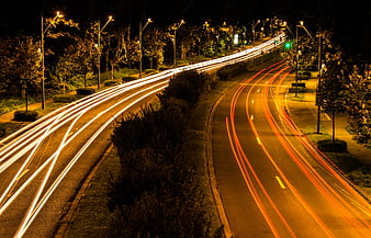 Long exposure light trails on a curved city highway at night