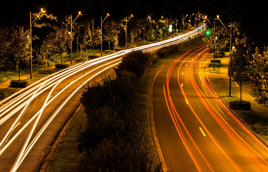 Long exposure light trails on a curved city highway at night