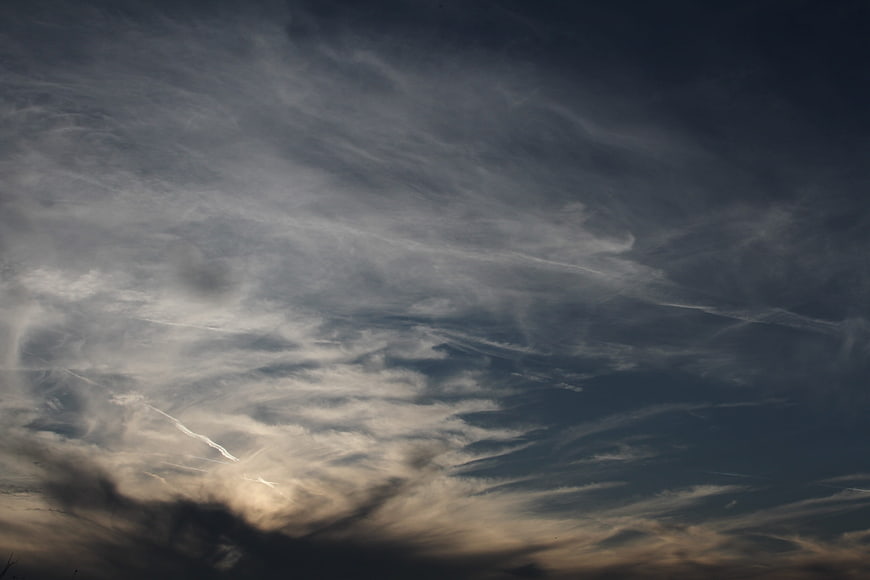 Dramatic dark clouds with sunlight breaking through at sunset
