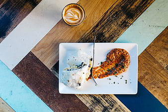 Overhead view of breakfast burrito and coffee on wooden table