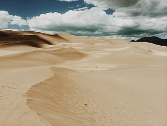Vast Sand Dunes Under Dramatic Cloudy Sky
