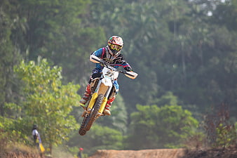 Motocross Rider Jumping Dirt Bike in Forest