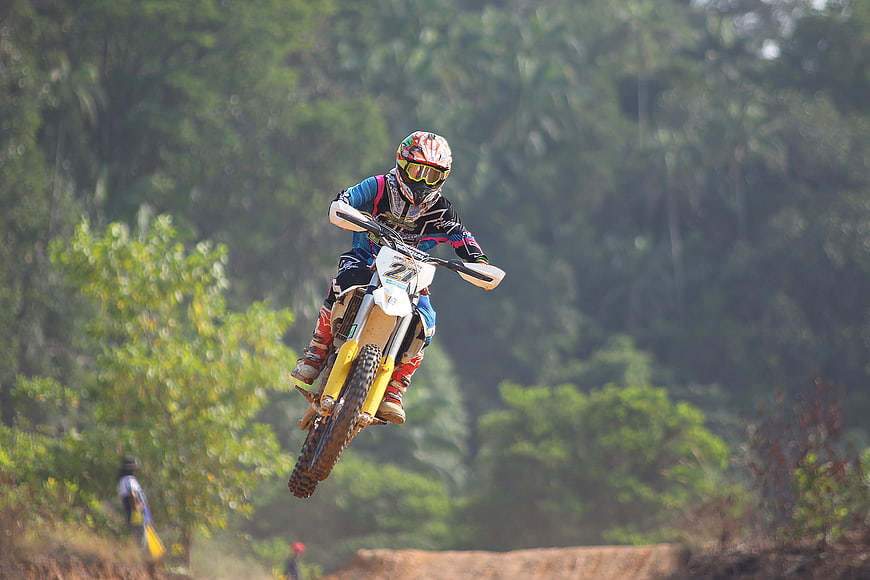 Motocross Rider Jumping Dirt Bike in Forest