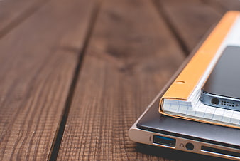Laptop, Smartphone, and Notebook on Wooden Desk