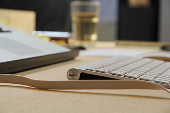 Close-up of white keyboard and laptop on wooden desk