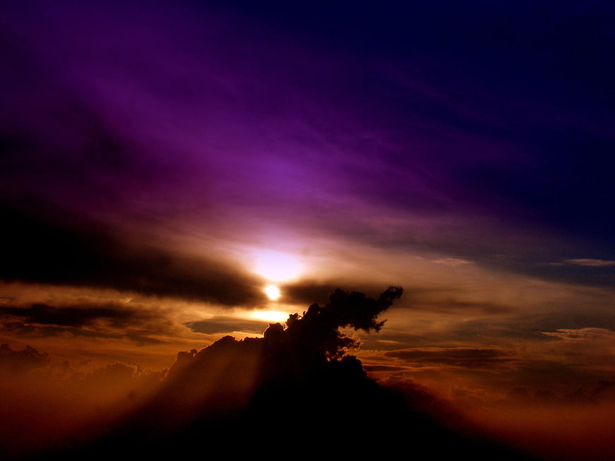 Dramatic purple and orange sunset sky with dark clouds
